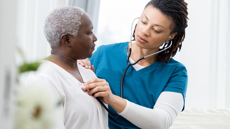 Healthcare provider using stethoscope on patient