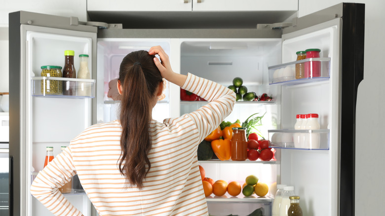 woman looking at contents of refrigerator