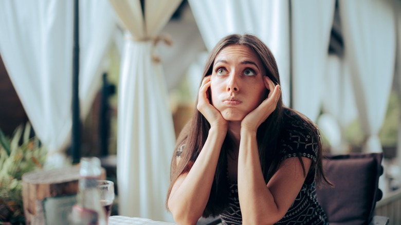 a woman looks stressed at dinner 