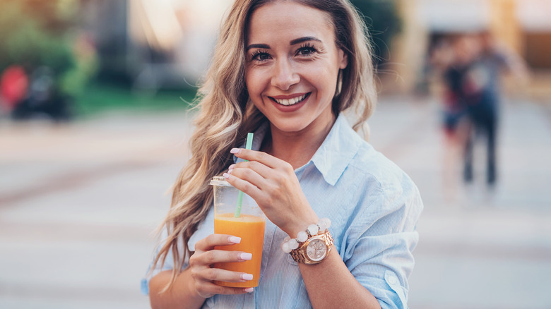 healthy woman drinking a smoothie outdoors