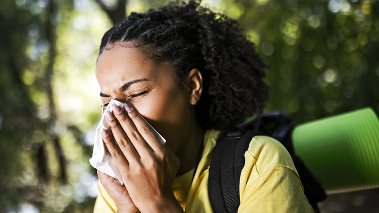 Woman with allergies hiking outdoors 