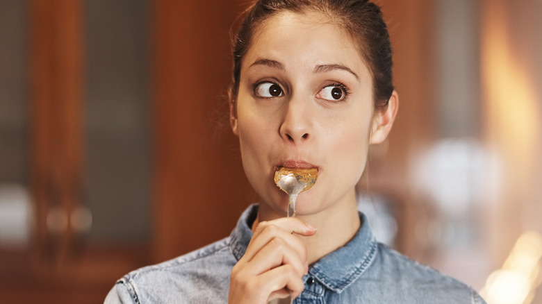 woman eating a spoonful of peanut butter