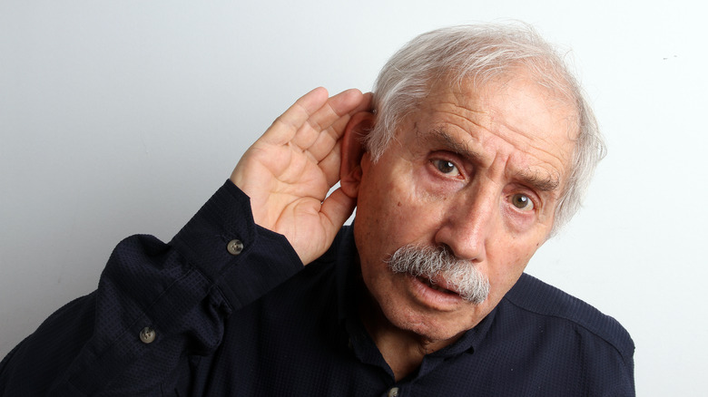 older man cupping his ear