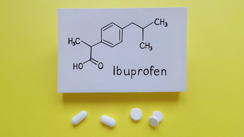 Photo showing chemical structure of anti-inflammatory ibuprofen, as well as pills in front of a yellow background