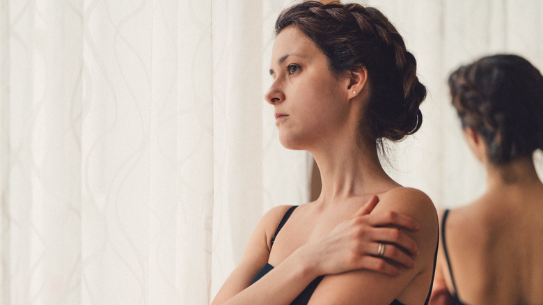 Woman looking thoughtfully out window