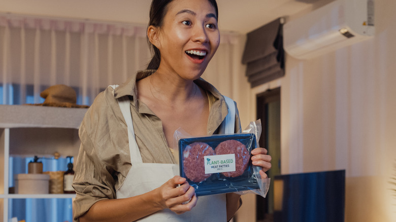 Woman holding plant-based meat patties