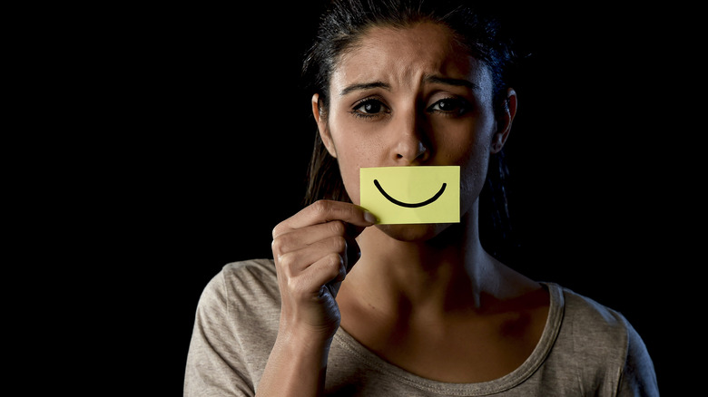 woman holding smiley post-it