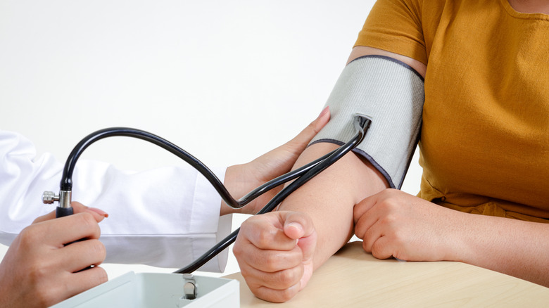 woman using blood pressure cuff