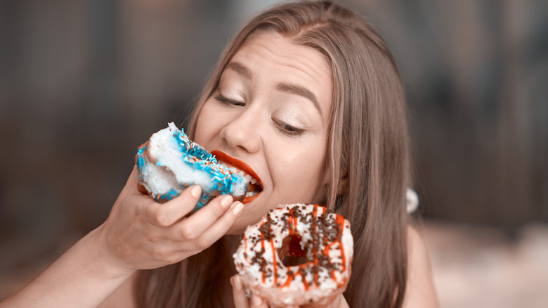 woman eating two donuts