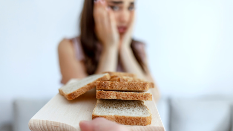 woman staring cautiously at slices of bread