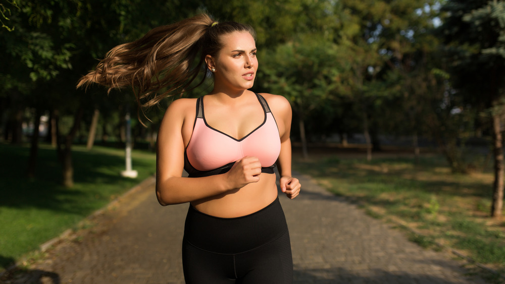 Young woman in sporty top and leggings jogging