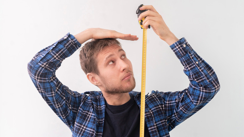 man with measuring tape height