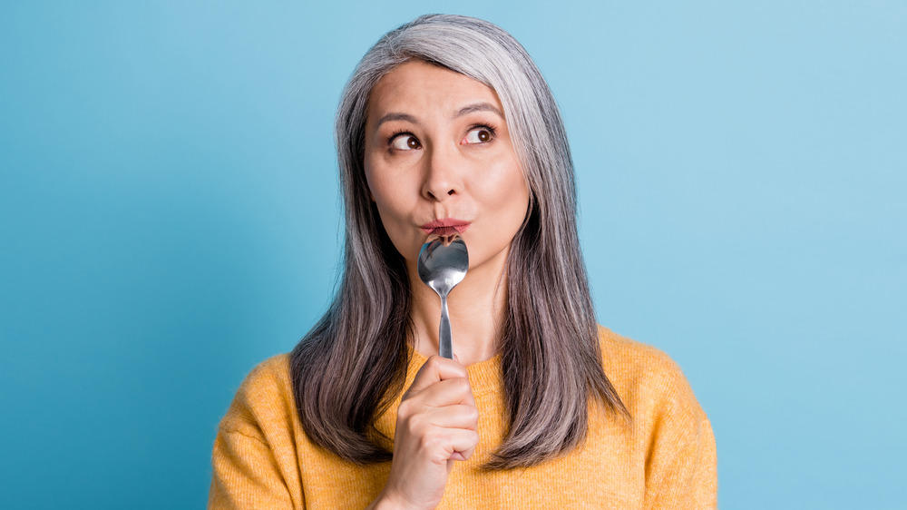 woman with empty spoon to mouth