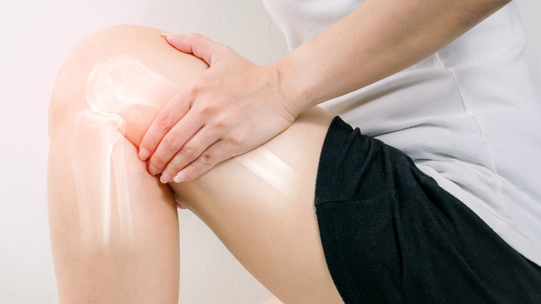 person holding leg with joint pain