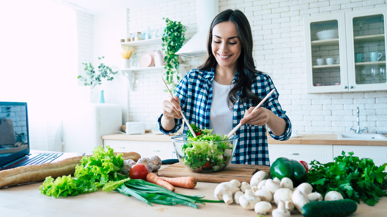 A woman is preparing a salad at home