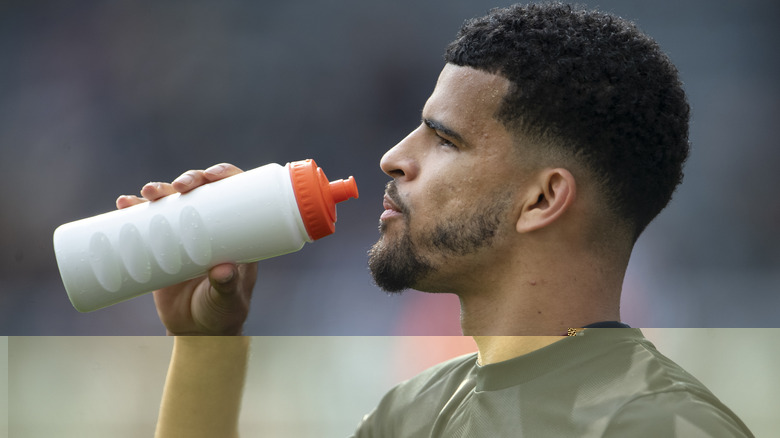 athlete drinking water from bottle