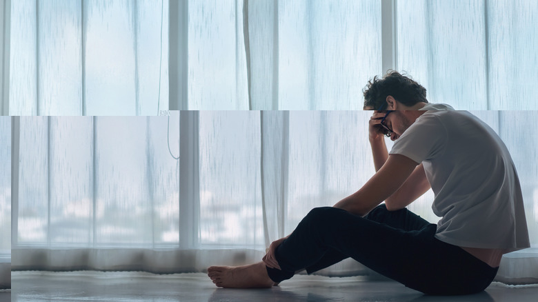 A depressed man sitting on the floor