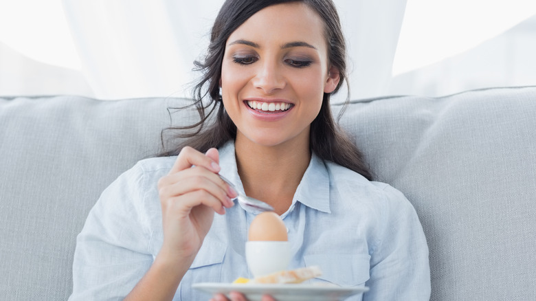 Young woman eating an egg