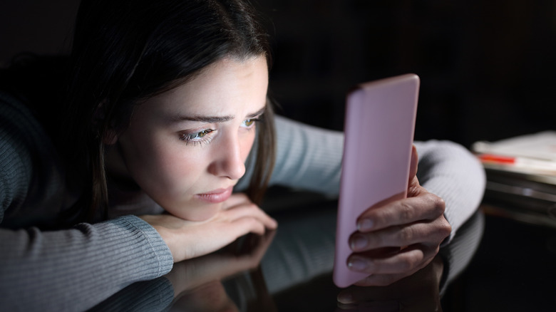 teenage girl unhappy on phone at night