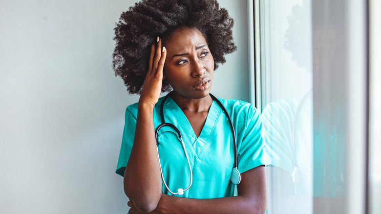 tired nurse looking out of window