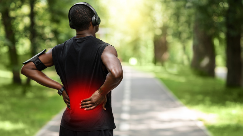 Person exercising outdoors experiencing back pain