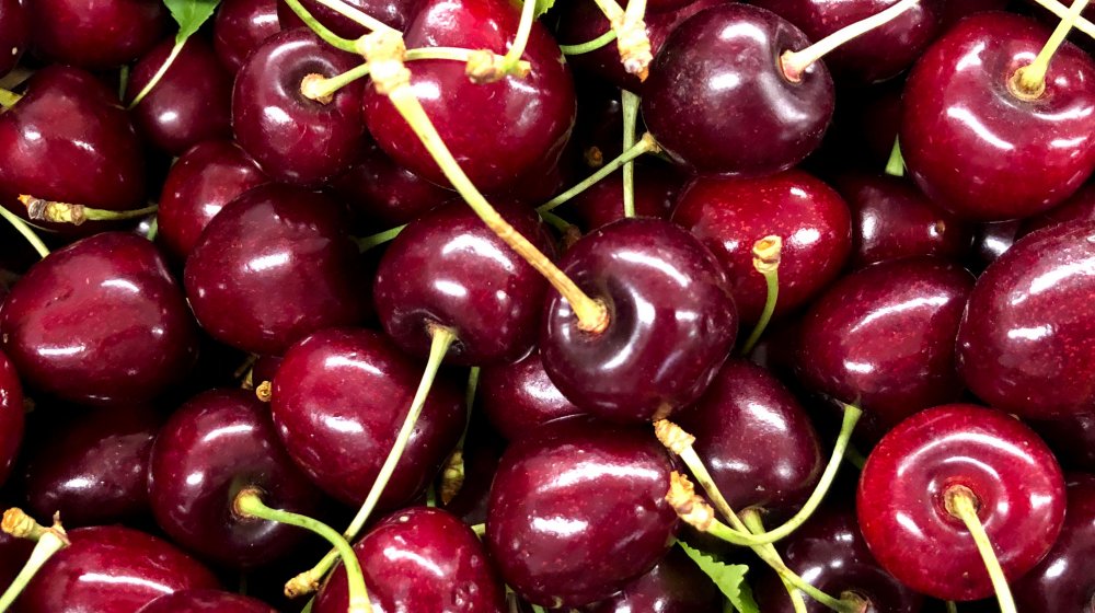 A pile of cherries on their stems 