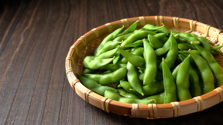 A bowl of edamame sits on a table