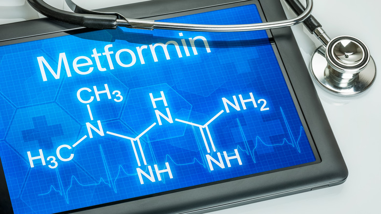 Tablet with chemical formula of metformin with stethoscope laying on it