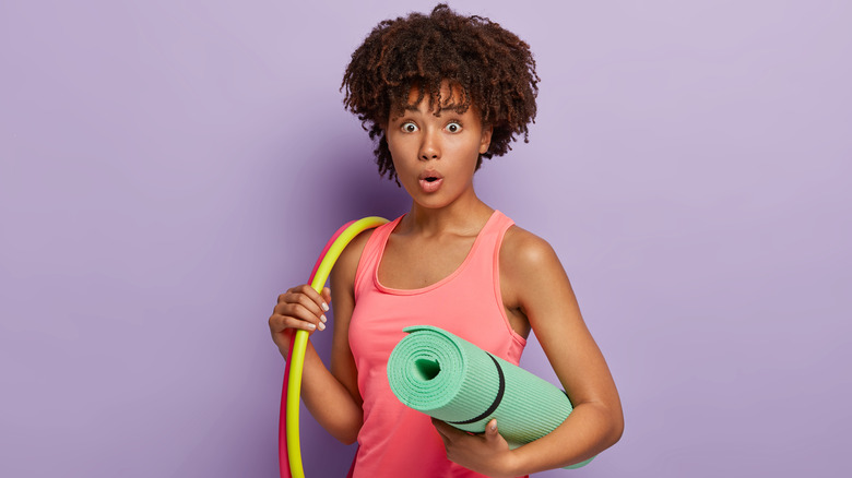 Black woman with exercise gear looking surprised