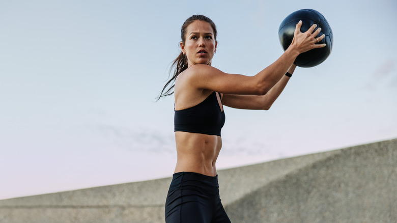 Fit woman holding up a medicine ball