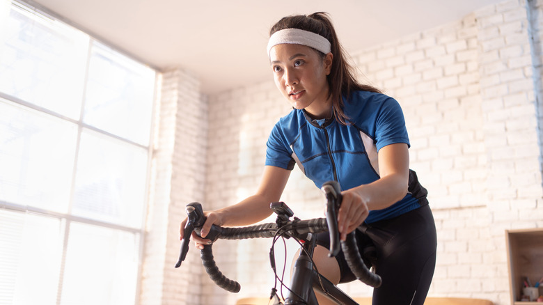 young woman looking intense while on a stationary bike