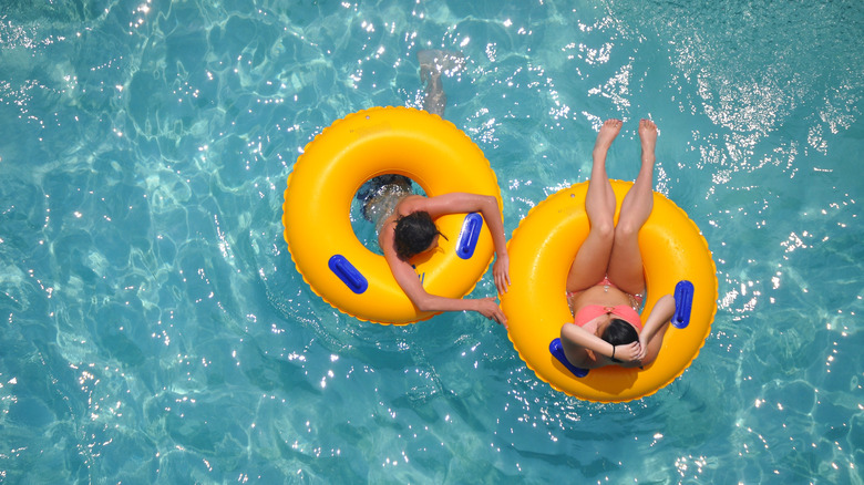women floating on tubes in pool