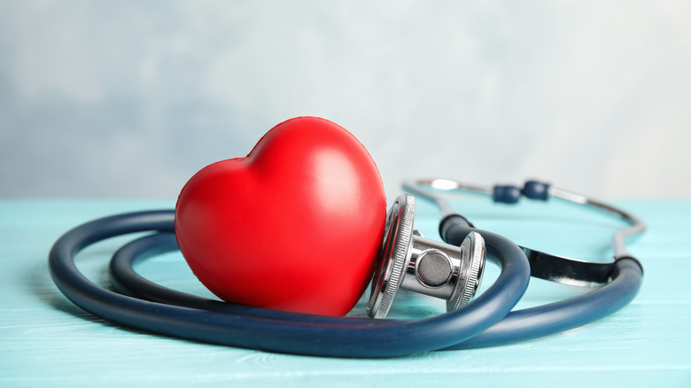 Red heart toy sitting inside a coiled up stethoscope