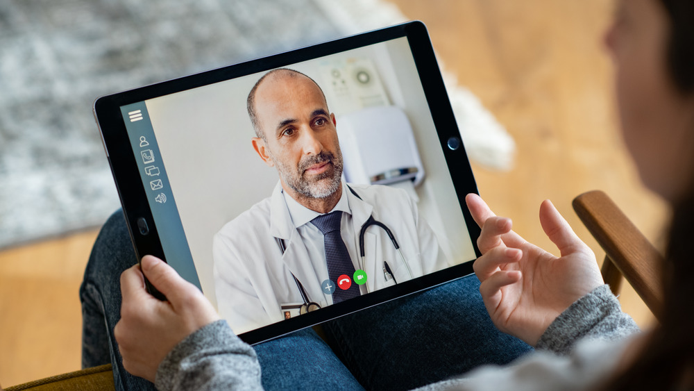 Patient holding an iPad with doctor on a virtual call