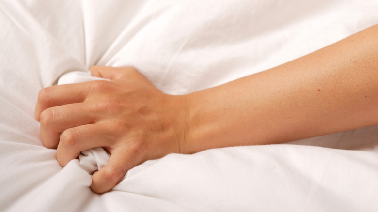 Hand grabbing onto a white sheet