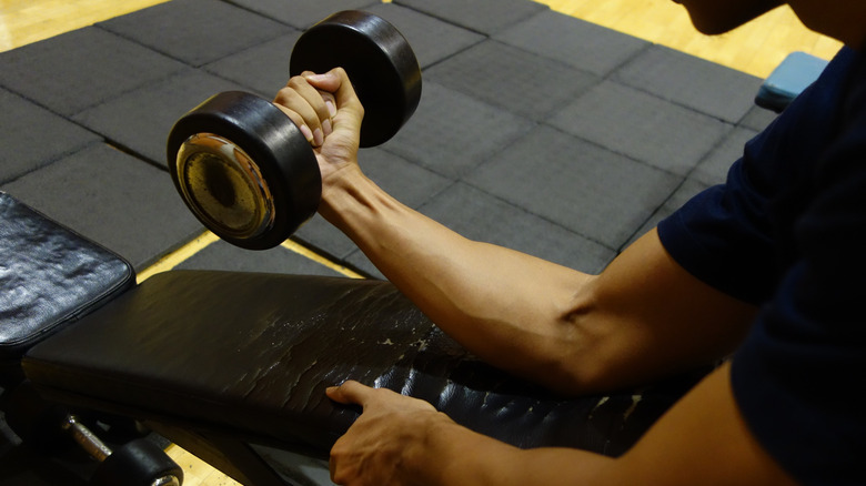 A man performs a wrist curl in the gym