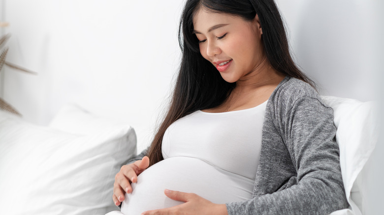 happy pregnant woman holding belly