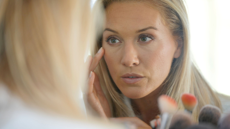 Woman analyzing skin in mirror