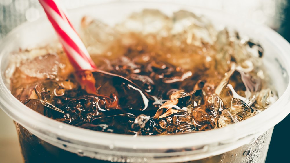 Bubbly dark soda with ice cubes and straw