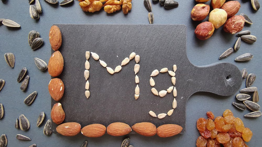 Nuts and seeds surrounding letters "Mg" spelled out in sunflower seeds