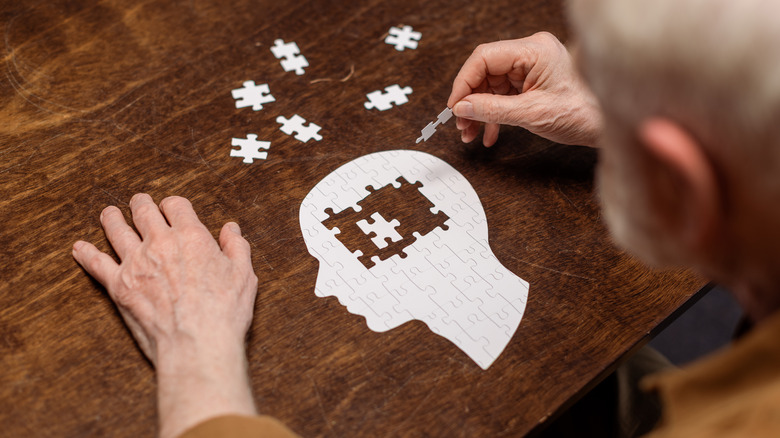 Person doing a paper puzzle in the shape of a human head