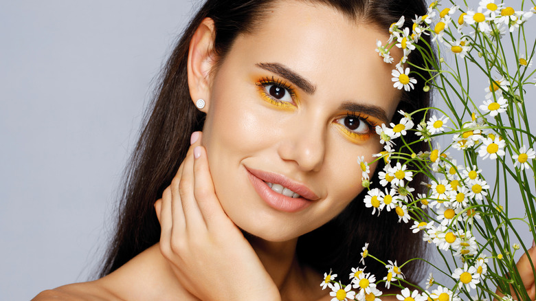woman's face with chamomile flowers