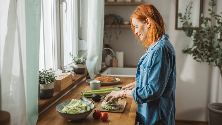 woman red hair chopping vegetables