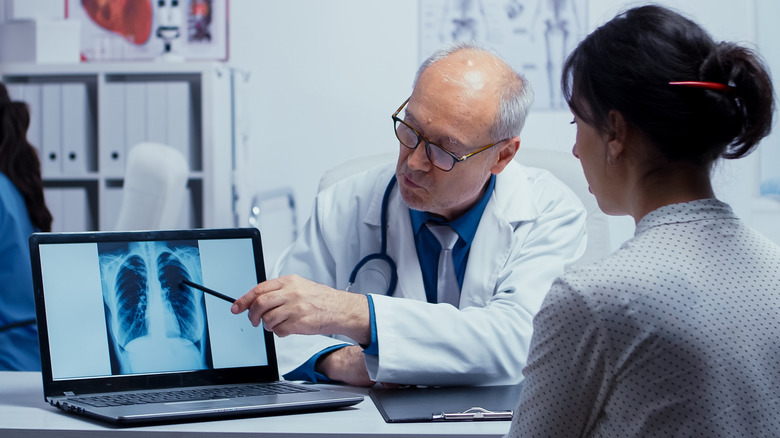doctor showing lung X-ray to patient