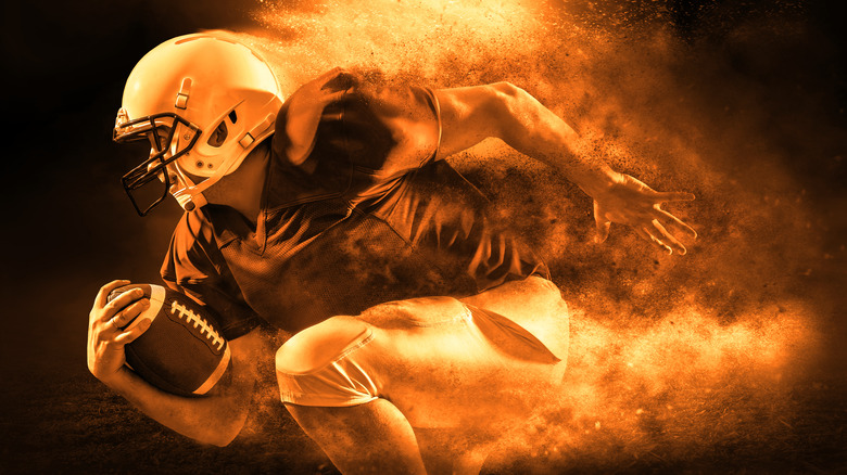 Football player running with fiery background