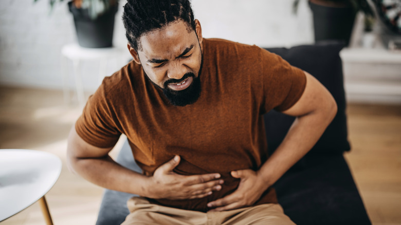 Man in pain holding stomach