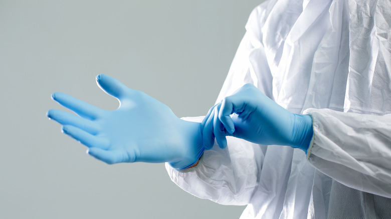Doctor putting on latex gloves