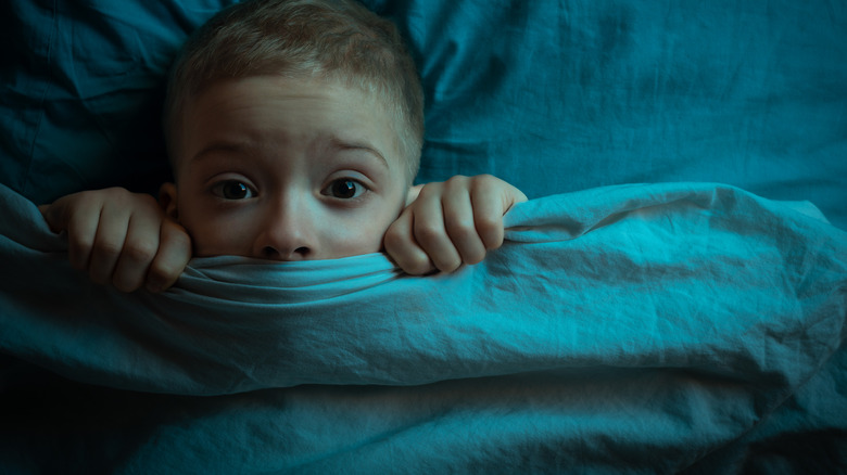 Child in bed under covers