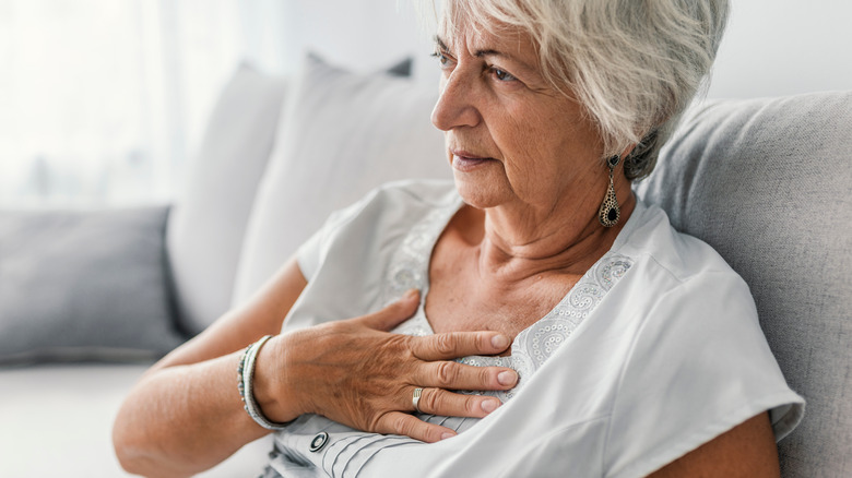 Older woman holding her chest in pain