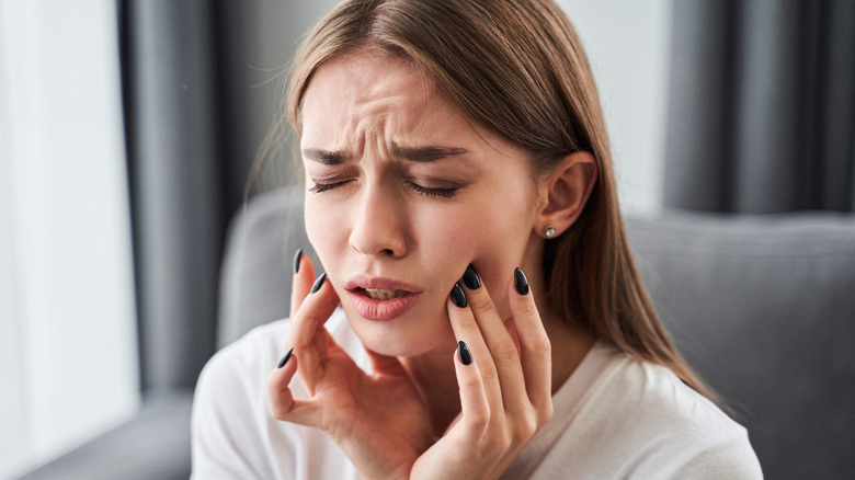 Woman with tooth pain grabbing face